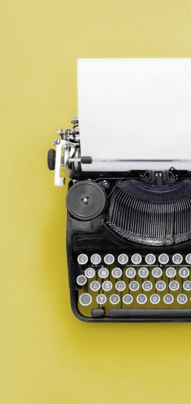 Vintage typewriter over blue background with copy space